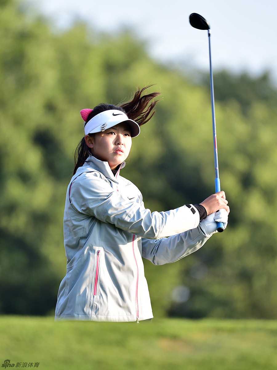 冯思敏在果岭旁施展精准的短切技术，小球划出优美抛物线飞向球洞。