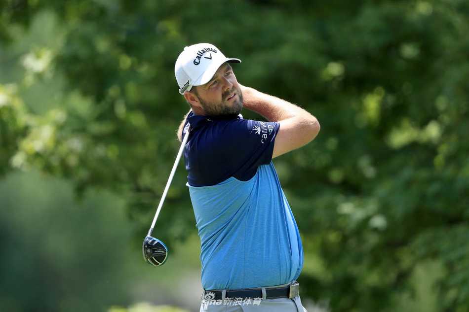 伍兹在沙坑边专注地观察同组球员贾斯汀·托马斯击打沙坑球，学习与评估不同的球场策略