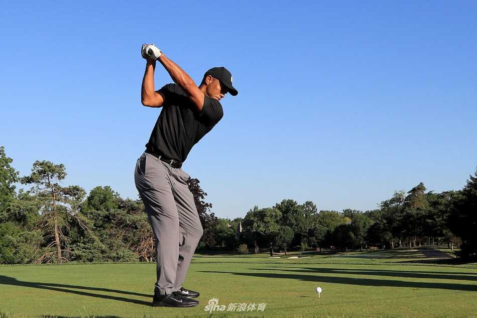 泰格·伍兹在练习轮中全神贯注地开出完美一杆，身体展现出标志性的流畅扭转与爆发力