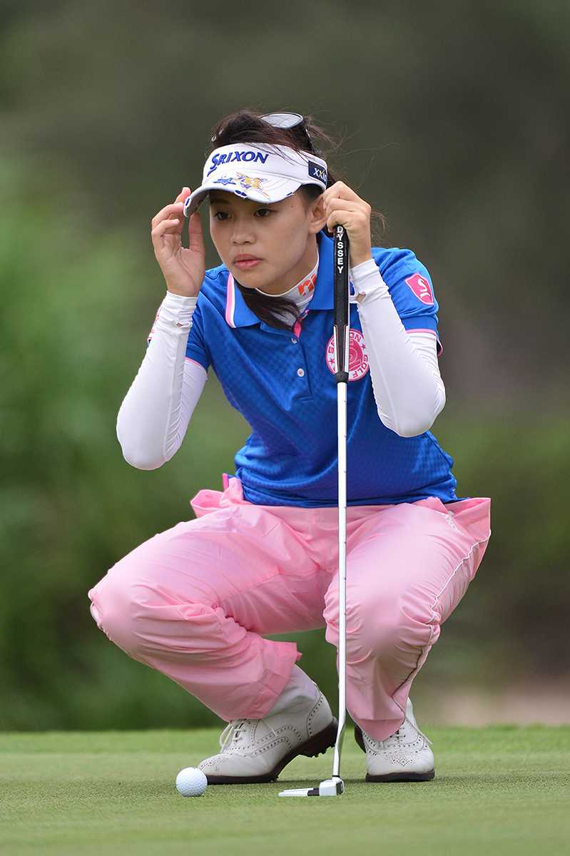 陈敏柔在果岭边全神贯注地蹲身观察，衡量着推杆的最佳路线与力度