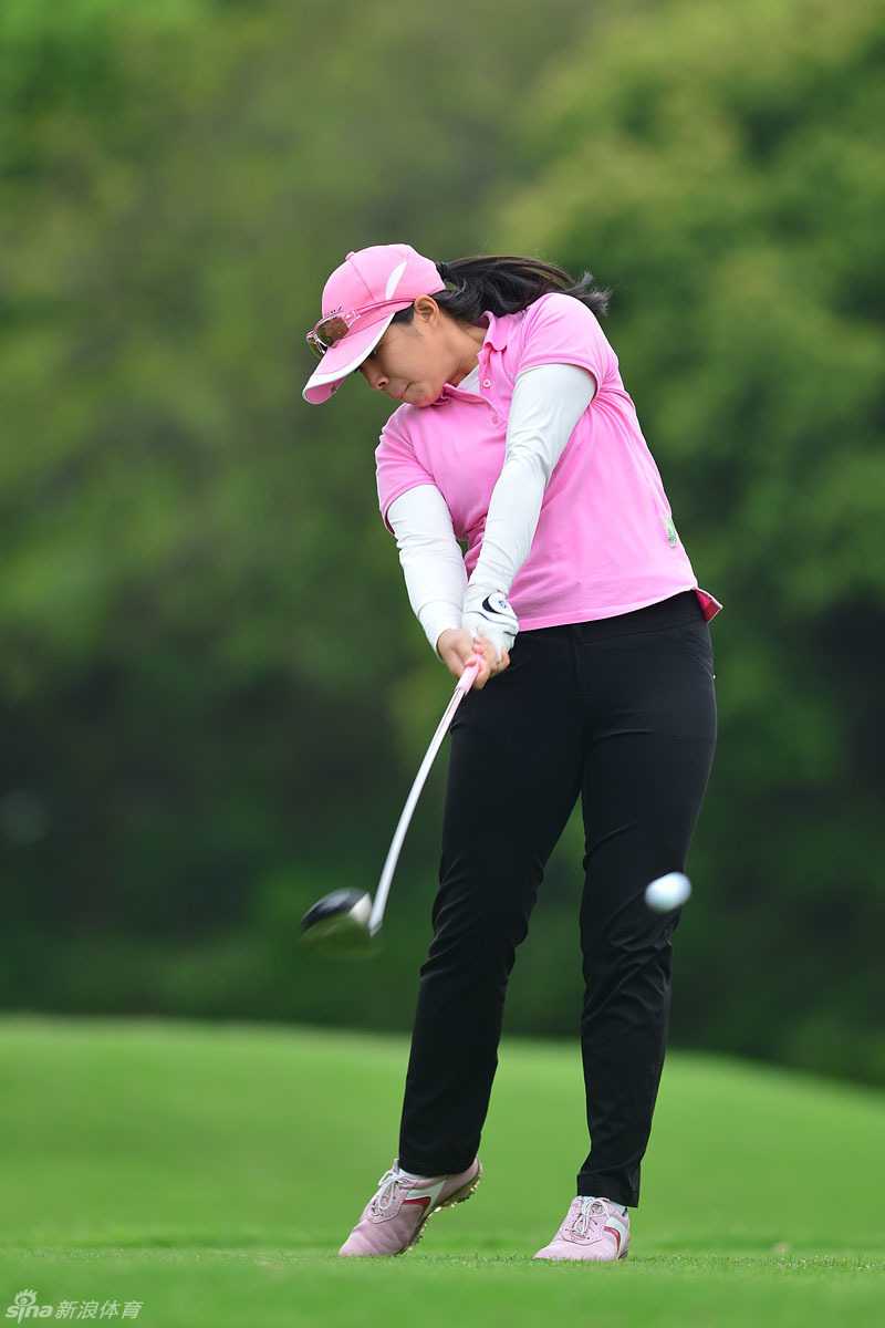 绿茵挥杆光影间 绿草如茵的球道上,球手李茜娅完成一记漂亮的击球后优雅收杆,动作流畅而平衡,仿佛与身后开阔的自然景观融为一体。