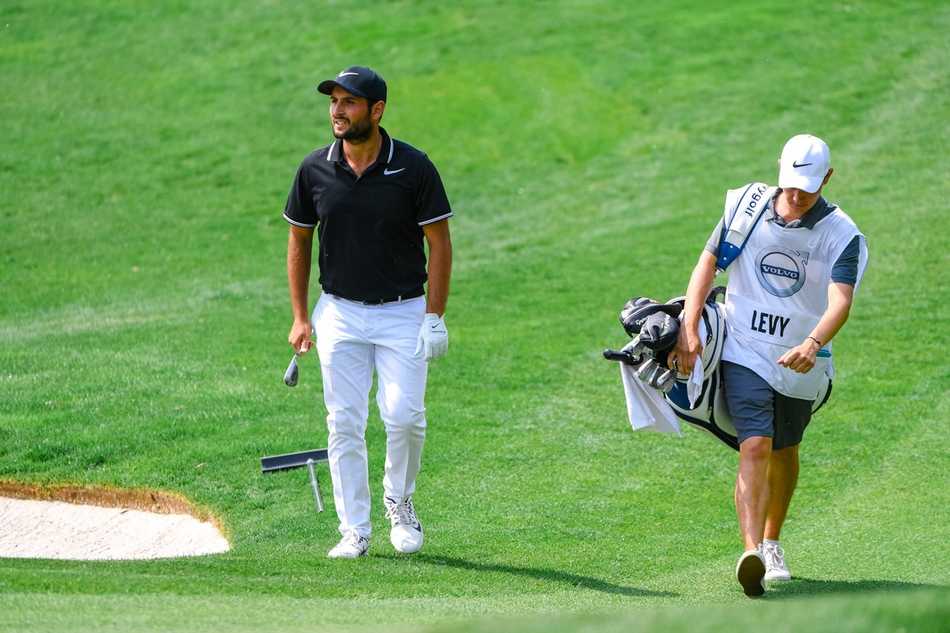 西班牙高尔夫名将帕布罗-拉拉扎巴尔正从长草区中谨慎地切击救球，眼神锐利地锁定小球。