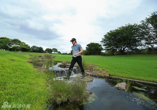 艾迪·佩珀罗尔沉稳地走过横穿球场的潺潺小河，他正专注于自己的比赛节奏，步伐坚定，展现了球员在复杂球场环境中从容不迫的专业态度。