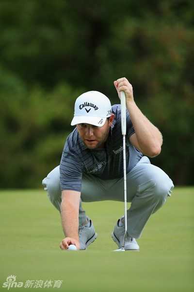 舒瓦泽尔在球道上用中铁杆攻果岭，他的挥杆动作协调而平衡，小球在空中划出高昂的抛物线，精准地飞向远处插着旗杆的果岭目标。