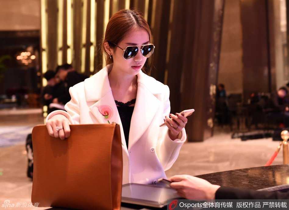 陈露提着随身物品走出酒店旋转门，准备乘车离开，她的背影修长挺拔，步伐轻盈，仿佛即将奔赴一场关于时尚与家庭的美丽之约。