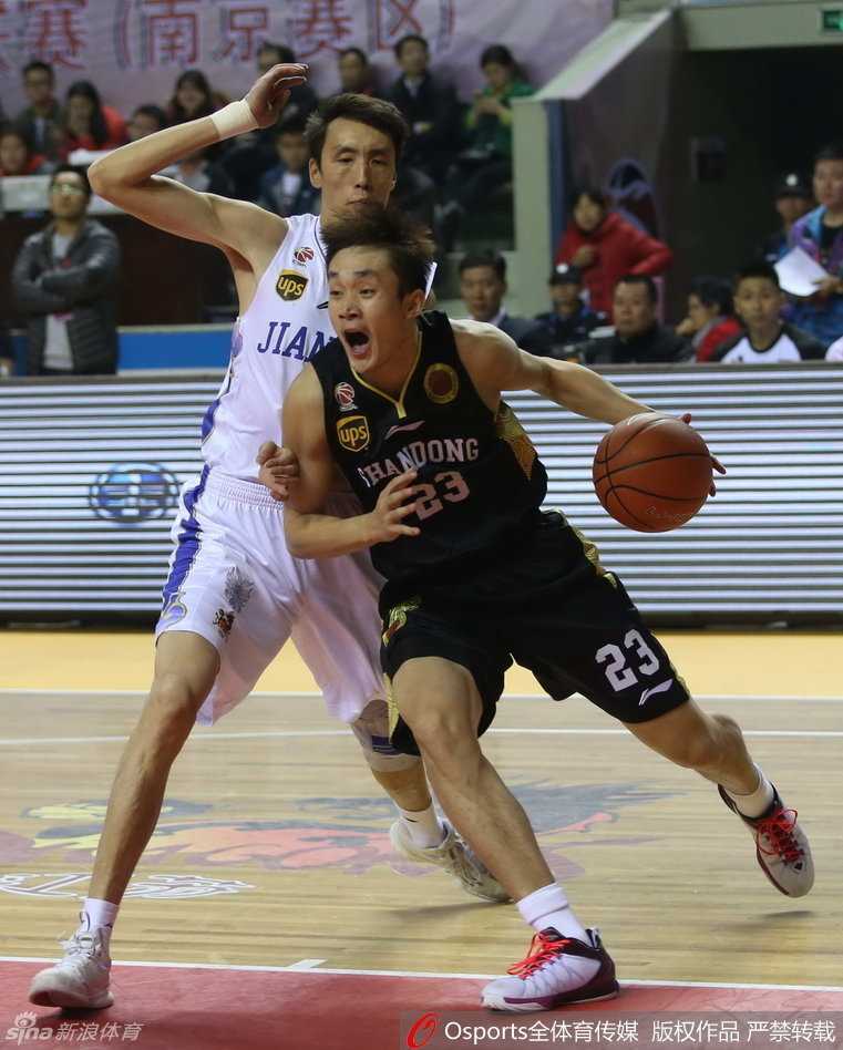 丁彦雨航持球从底线强行切入，眼神坚定，突破防守球员的封堵直杀篮下