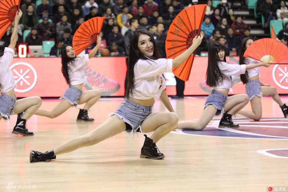 啦啦队队长高举双手，用灿烂如阳的笑容和有力的动作，引领全场的助威节奏