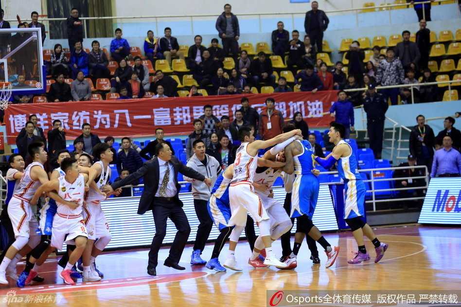cba赛场爆发大规模冲突 八一福建上演全武行 在一片混乱中,福建外援泰勒被多人围住,显得孤立无援,场边的球迷也站起来张望,整个球馆被紧张和混乱的气氛笼罩。
