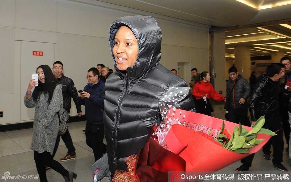 在球迷的簇拥下，玛雅·摩尔推着满载行李的推车走出机场，脸上依然挂着温柔而感激的笑容，仿佛一场盛大的欢迎仪式。