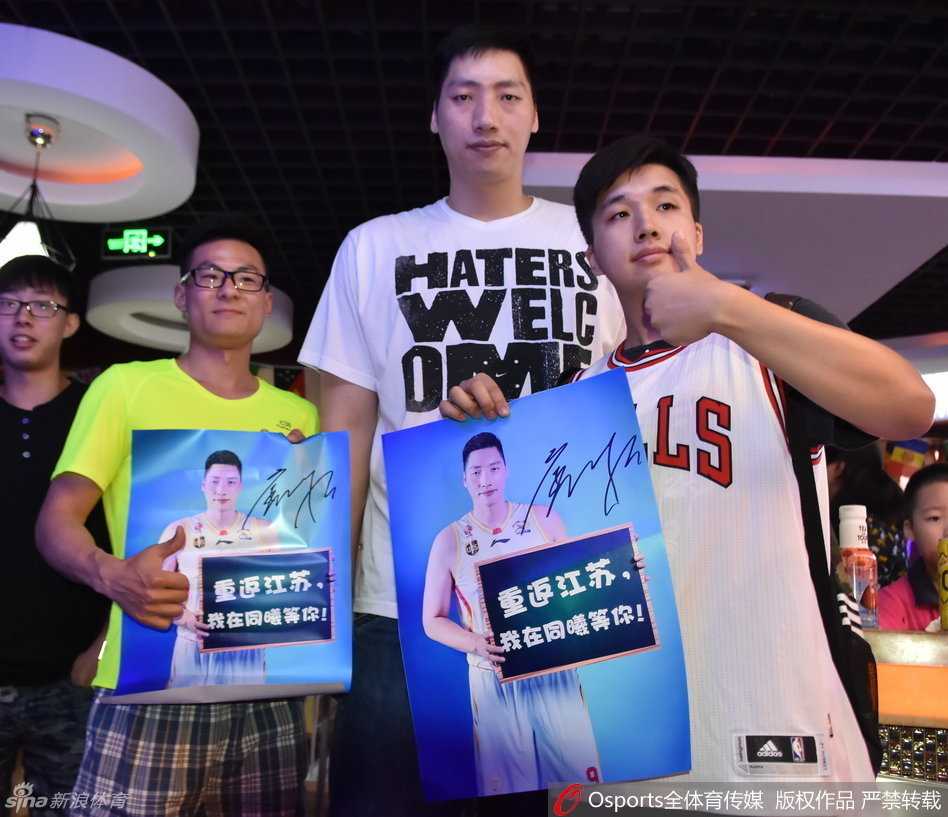 唐正东身穿灰色T恤，在合影区被一群来自同曦篮球训练营的小球员们团团围住，他高大的身影宛如一座灯塔，小球员们簇拥在他身边，脸上满是兴奋与崇拜。