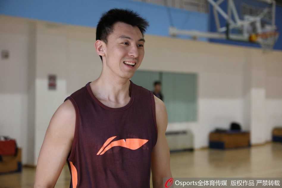 训练场边的吉喆笑容满面，正与队友交流心得，他手臂上结实的肌肉线条在灯光下显得格外清晰，整个人的状态非常放松。