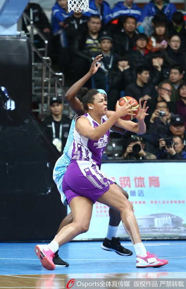 北京队球员在严密包夹下依然奋力完成篮下进攻，眼神中透露出对胜利的无限渴望