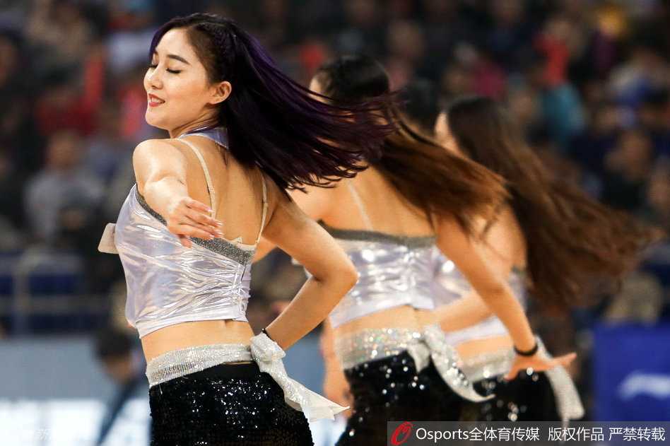 即使是在表演的间隙，镜头捕捉到一位宝贝额头渗出汗珠却依然保持微笑的特写，这份隐藏在光鲜背后的付出与坚持，与不远处正在激烈拼抢的球员身影交相辉映，诠释着同样的敬业精神。