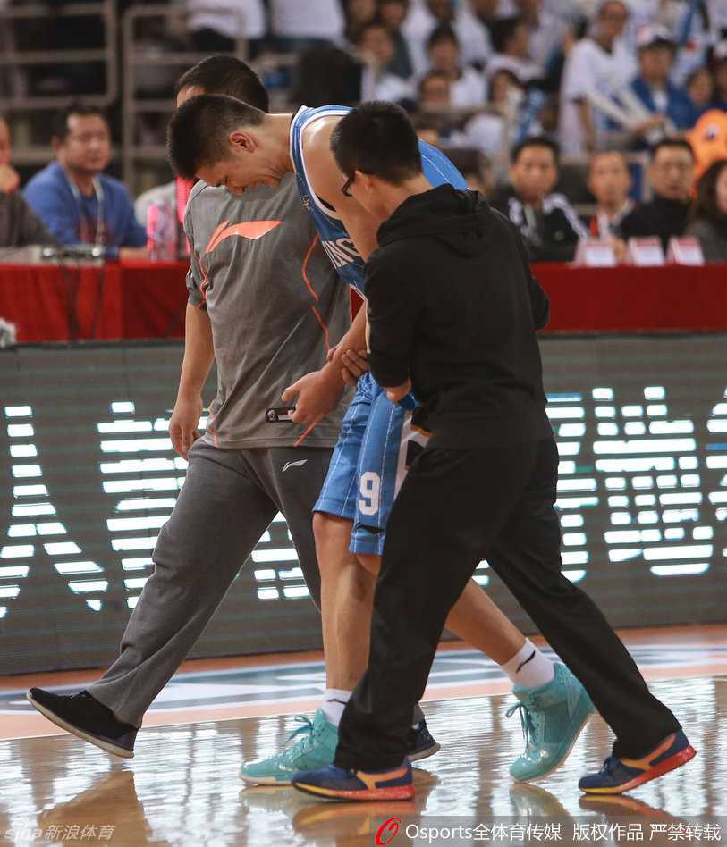 孙悦在拼抢中痛苦倒地，左手紧捂伤臂，面部表情因剧痛而扭曲，身旁的北控球员也遗憾地看着他。