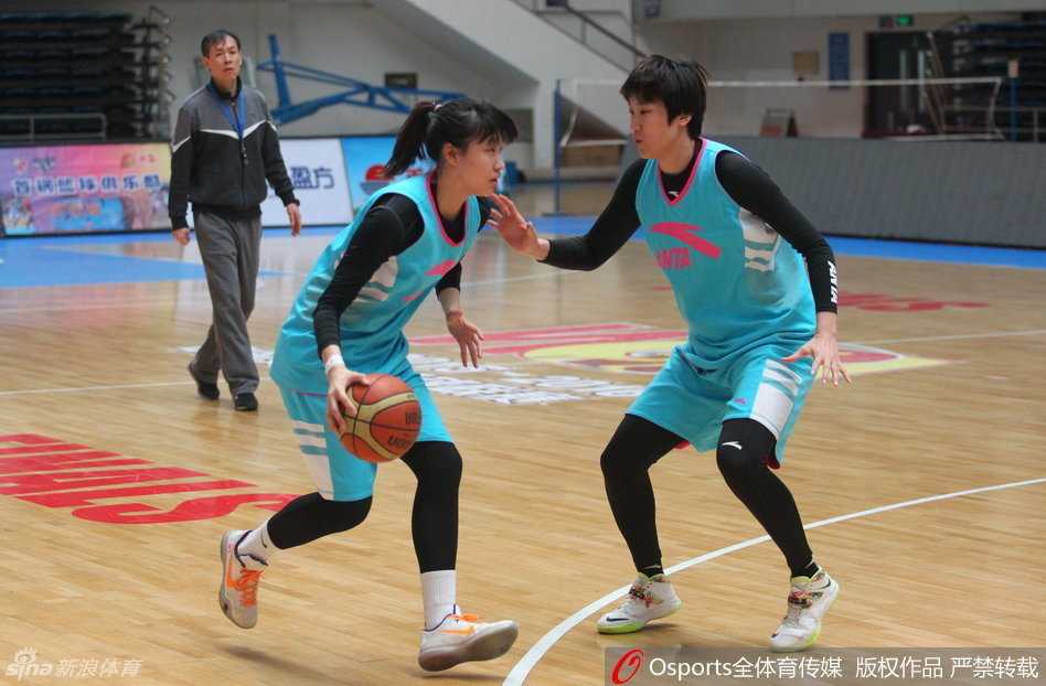 在战术板前，主帅许利民目光如炬，正用手势向邵婷强调着第四战的防守要诀，身后的备战海报透露出决战前夕的紧张气氛。