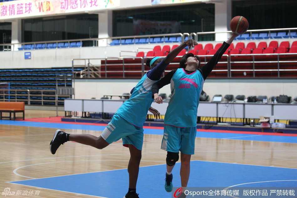北京女篮进行分组对抗，球鞋与地板摩擦发出尖锐声响，球员们奋力拼抢篮板，训练强度堪比实战。