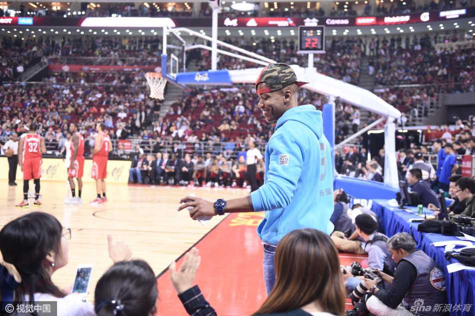 京城英雄场边坐 马布里五棵松静候新赛季 马布里侧身倚靠在座位上,脸上挂着标志性的灿烂笑容,举起手臂向四周认出他的热情球迷挥手示意,仿佛老朋友见面般亲切。