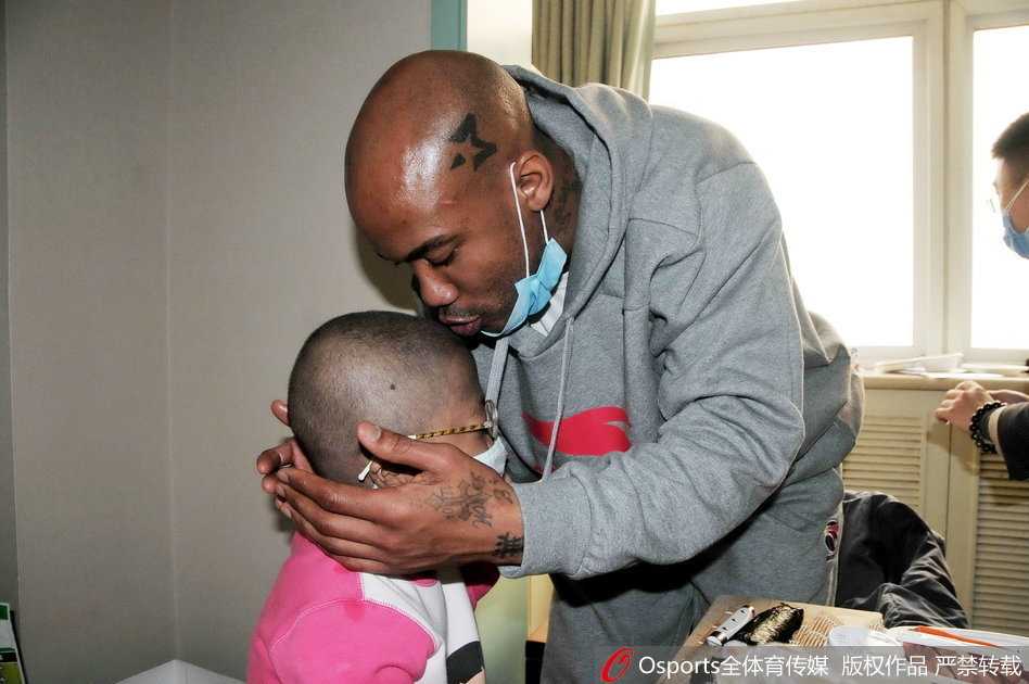 从纽约到北京:马布里的中国情缘 社区居委会门口,马布里戴着口罩与几位身穿工作服的社区大姐站在一起,他手里举着隔离期满证明,大家对着镜头一起竖起大拇指