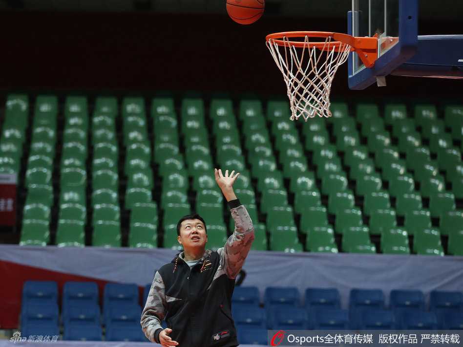 从追风少年到传奇教头:王治郅的赛场内外 王治郅神情专注地持球准备示范,虽然身着便装,但持球的姿态依旧标准,仿佛瞬间回到了球员时代。