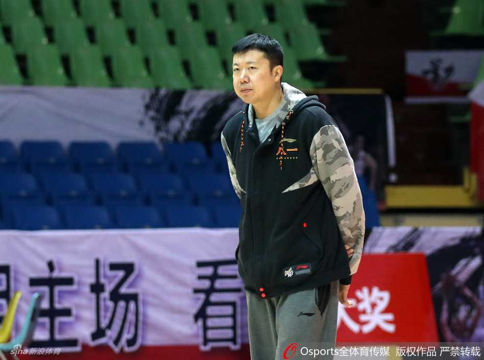 从追风少年到传奇教头:王治郅的赛场内外 新任教练王治郅在场边神情专注地观看着队员们的训练,双臂环抱,眼神中透露出作为主帅的严肃与责任感。