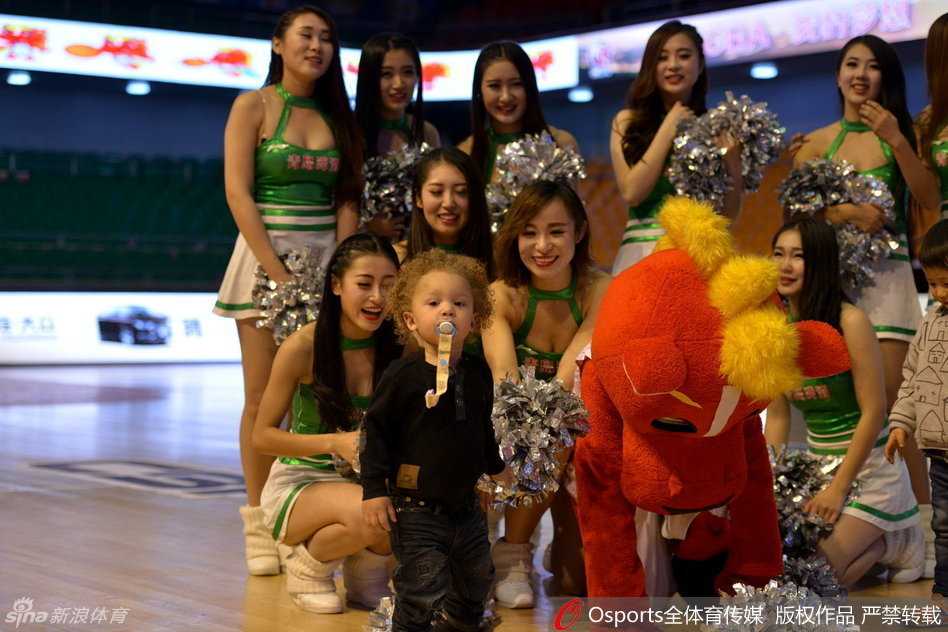 被父亲紧紧抱在怀里的他，仿佛化身守护父亲的‘小蝙蝠侠’，黑色的外套配上圆溜溜的眼睛，在聚光灯下显得既神秘又可爱。