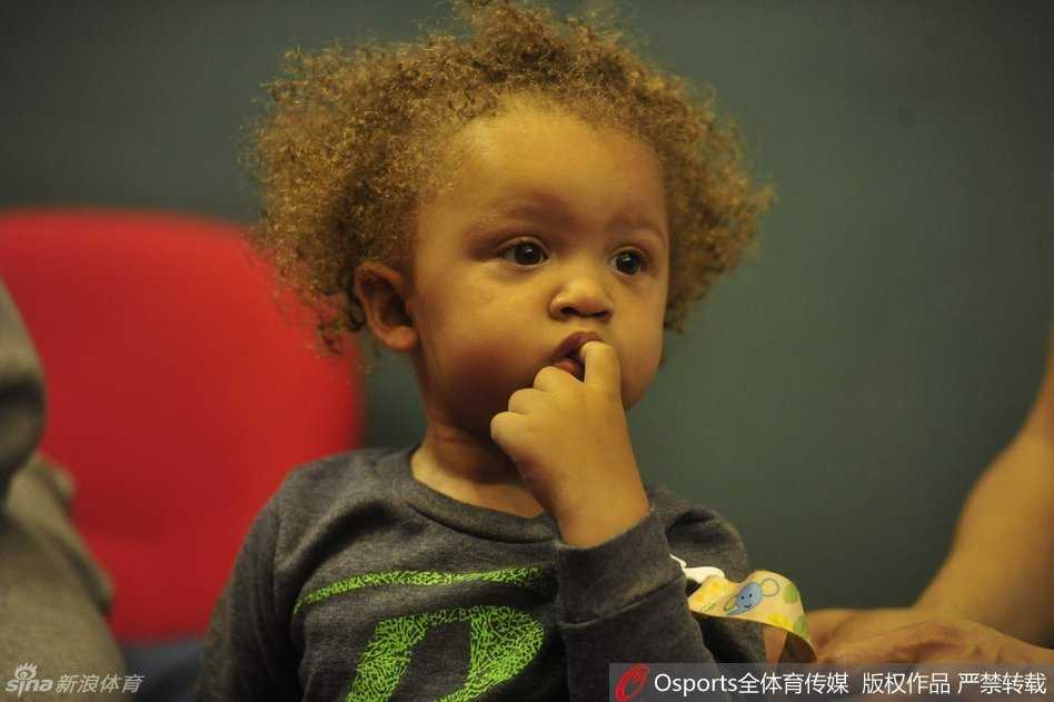 胖嘟嘟的小手放在嘴边，比斯利的爱子睁着圆溜溜的大眼睛，懵懂地打量着喧闹的CBA全明星赛场，无辜的小表情瞬间融化了观众的心。