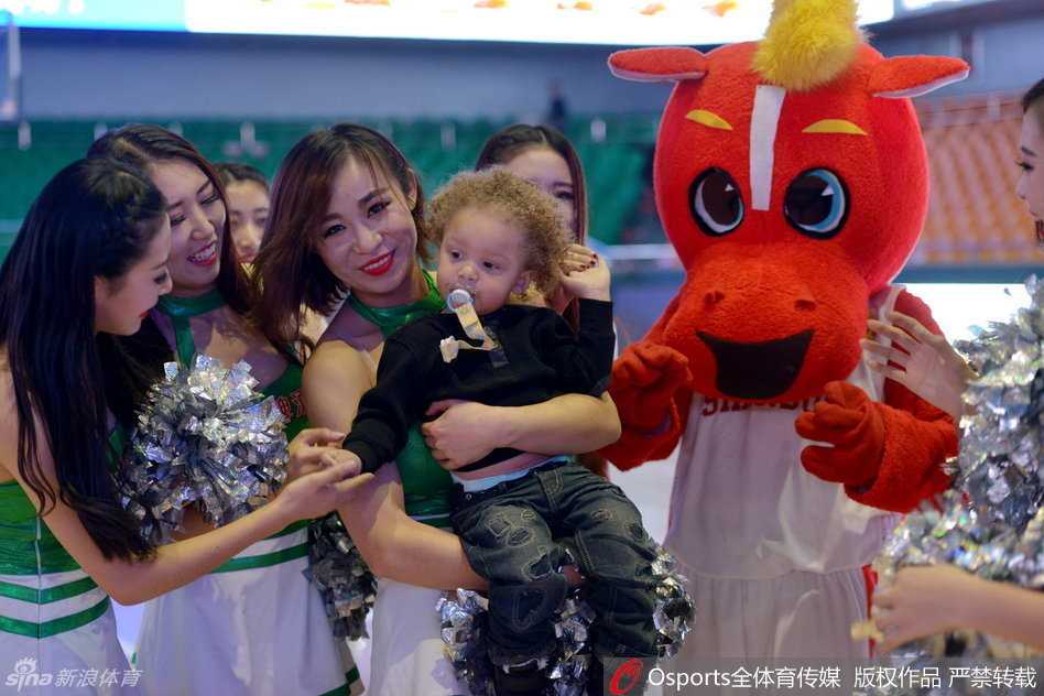 父子俩温馨同框，比斯利目光柔和地看着怀里的儿子，小家伙则安心地依偎在爸爸怀中，这一幕让激烈的全明星赛场充满了家的温情。