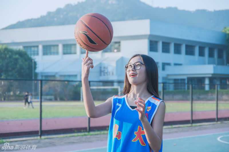 任丹妮身着简约白T站在绿荫树下，清新甜美的微笑如同校园里的一阵清风，让人瞬间回到那个单纯的篮球夏天。