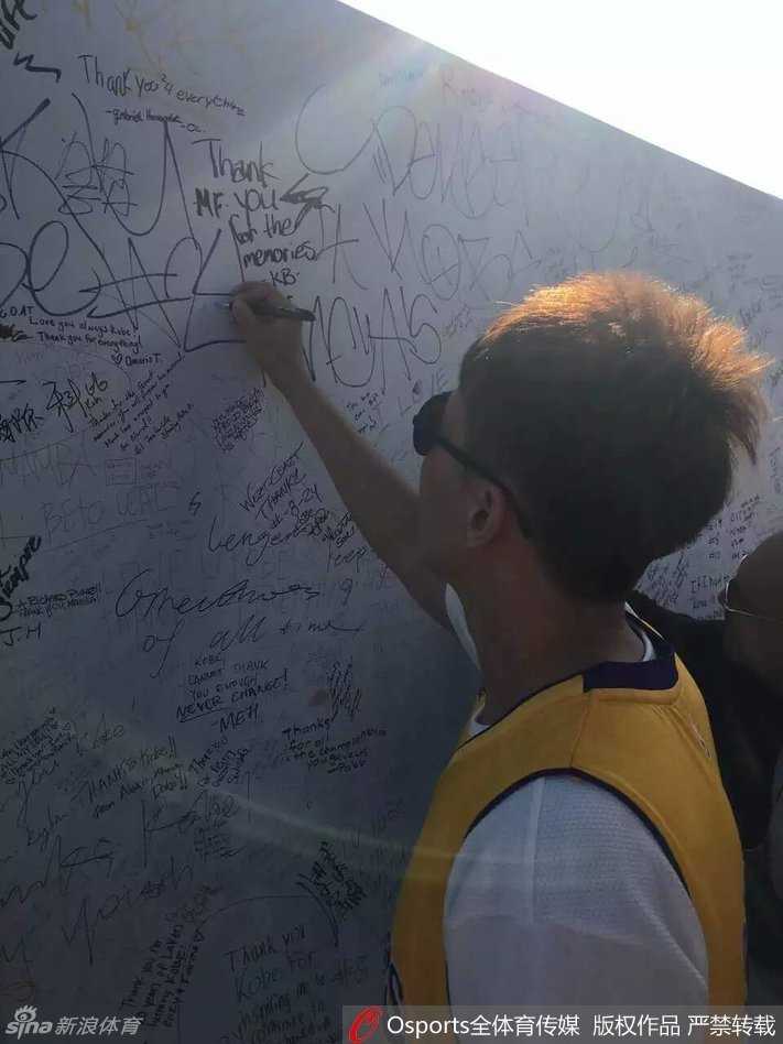 再见科比,再见青春:曾令旭的斯台普斯朝圣之旅 斯台普斯中心外,人潮涌动,曾令旭身穿醒目的紫金24号球衣,在科比的巨幅海报前停下脚步,眼神中满是期待与崇敬,用手机记录下这即将圆梦的一刻。
