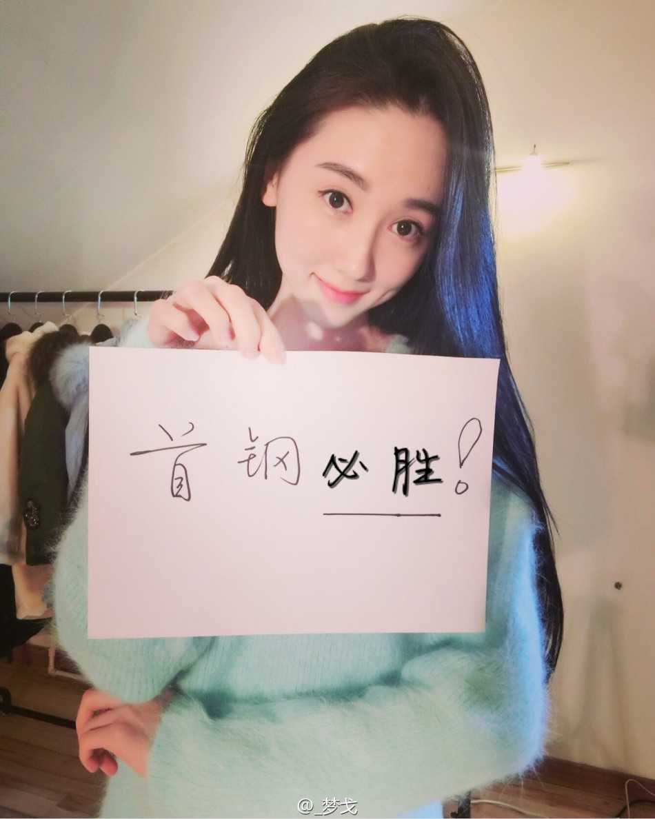 夕阳余晖洒在首钢女球迷身上，她回眸一笑，身后的CBA赛场灯光仿佛为她而亮，温柔与力量在此刻交融