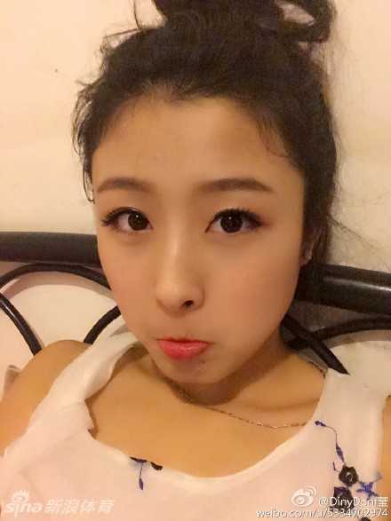 黄思莹身穿深色牛仔短裙搭配简约白T恤，倚靠在栏杆上，回眸一笑，展现出生活中邻家女孩的清纯气息