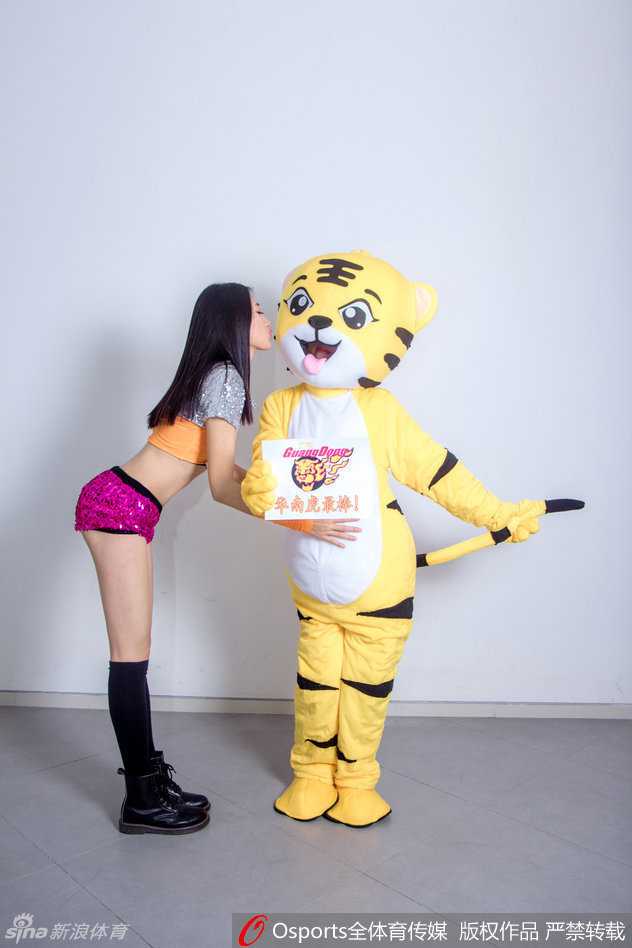 华南虎啸背后的温柔力量:宏远篮球宝贝与吉祥物的主场故事 两位篮球宝贝紧紧抱着那只顽皮的华南虎吉祥物,虎头在两人中间被挤得有些变形,但依然努力保持着标志性的咧嘴笑,这张搞怪合影将赛场下的轻松友爱定格成了永恒。