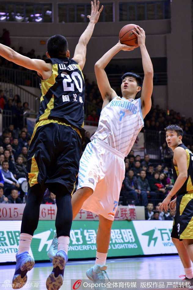 新疆队的内线支柱周琦，在对方两人的夹击缝隙中依然从容出手，他那修长的手臂如同巨塔般将球稳稳送入篮筐。