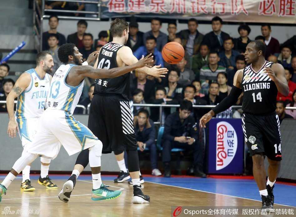 郭士强在场边双手合十，神情专注地指挥比赛，背后是沸腾的球迷看台，他的背影显得坚定而执着。