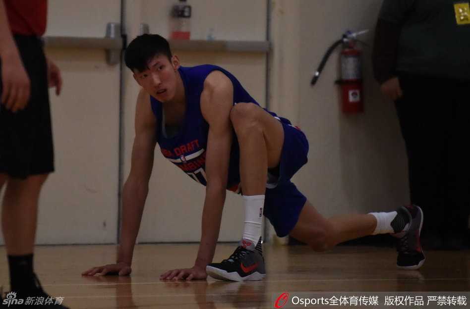 在正式开始严苛的体测之前，周琦神情专注地进行着热身活动，拉伸筋骨，为即将到来的挑战做好万全准备。