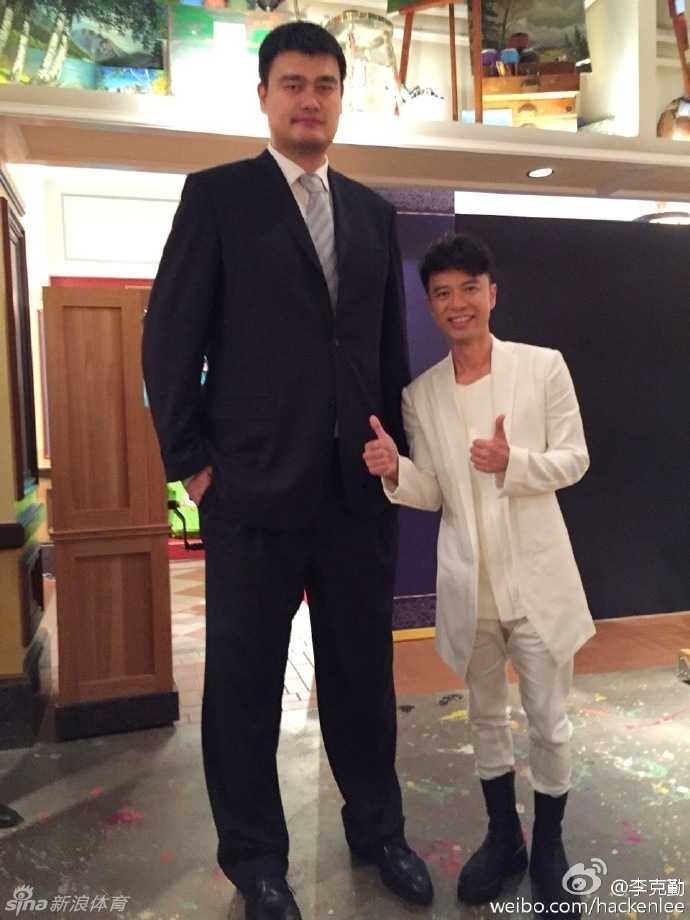 姚明被众星环绕，有人踮脚有人仰头，大家笑容满面地展现最萌身高差合影