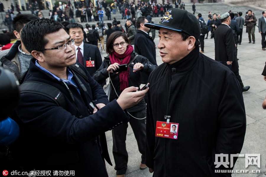 在庄重的会场内，姜昆与其他委员并肩而坐，他目光专注地凝视着发言者方向，神情投入地倾听其他政协委员的精彩讲话。