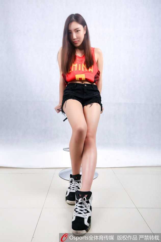 一位篮球宝贝侧身微笑，清秀的面庞在光影下显得格外动人，乌黑的长发自然披散，流露出邻家女孩般的温婉气质。