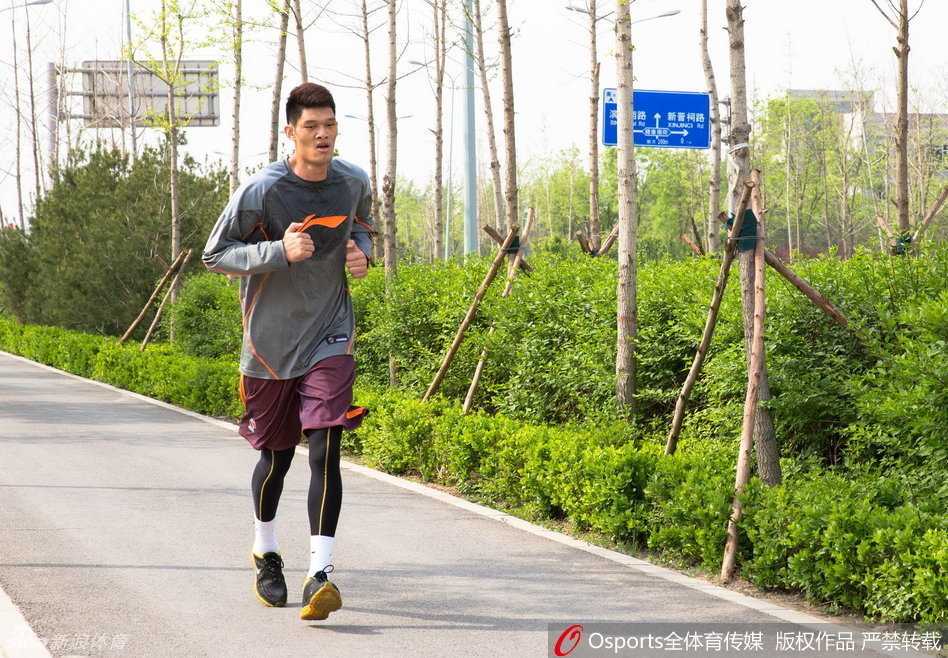 后卫球员田桂森在队友的防守下强行突破，肌肉线条分明，浑身被汗水浸透，充满了力量感。