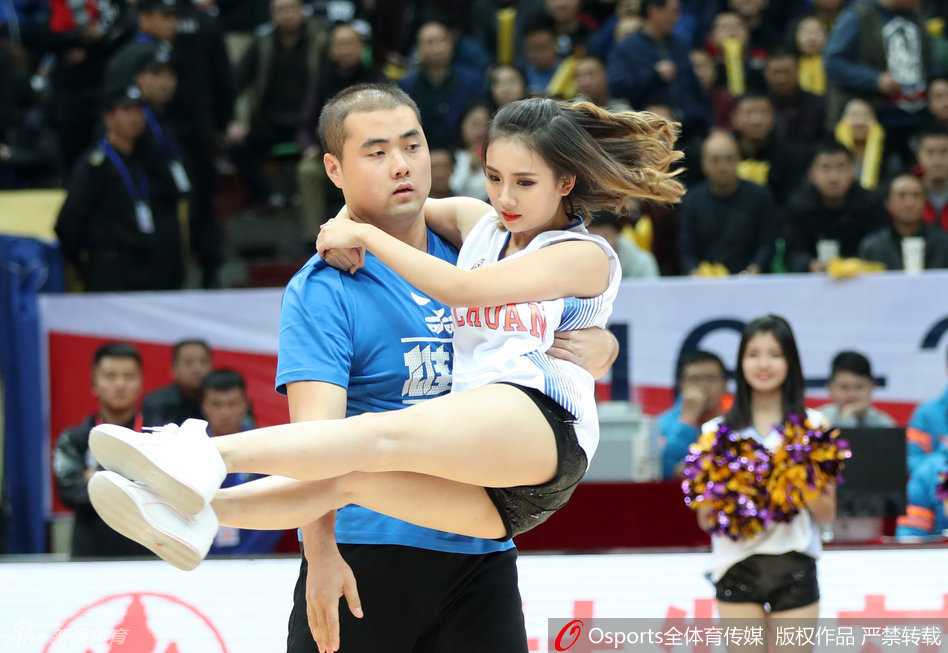 身穿红色民族风服饰的啦啦队队员在赛场中央扭动身子，舞姿灵动中带着一丝俏皮，仿佛在向观众说‘放开那个妹子！’，用活力抢占镜头