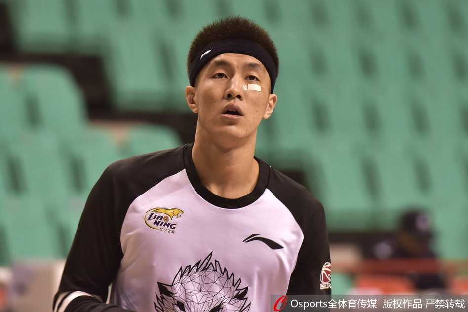 郭艾伦在热身时认真地进行运球练习，黑白色的球衣搭配头带和创可贴，展现出他硬朗的比赛作风。