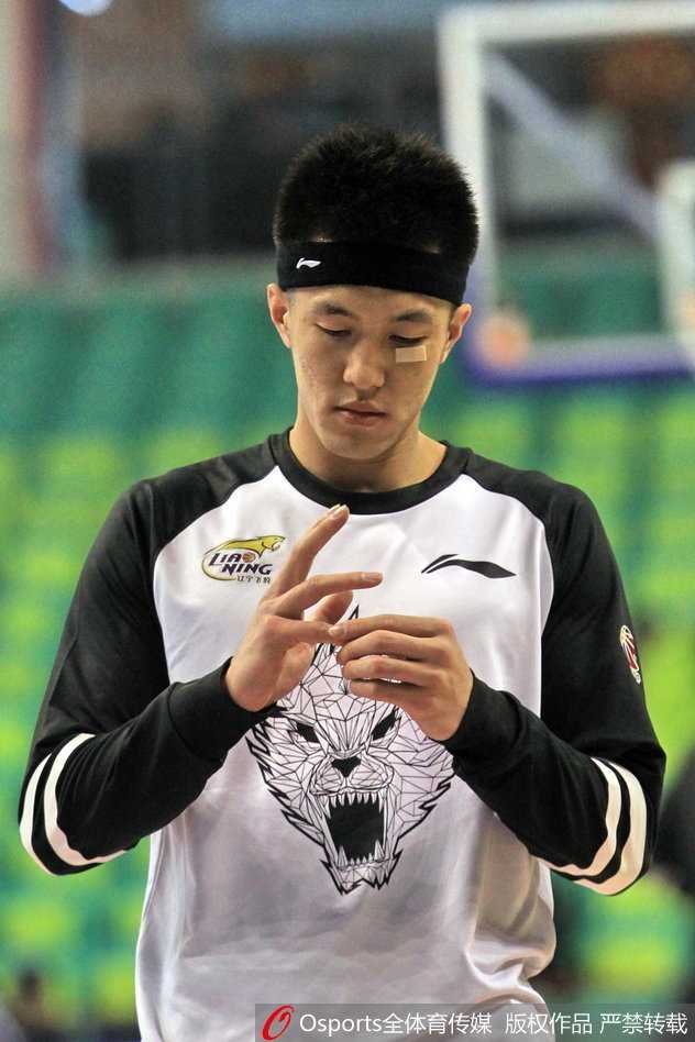 郭艾伦与队友击掌相互鼓励，赛前的热身氛围轻松而又充满斗志，他脸上的创可贴在灯光下格外醒目。