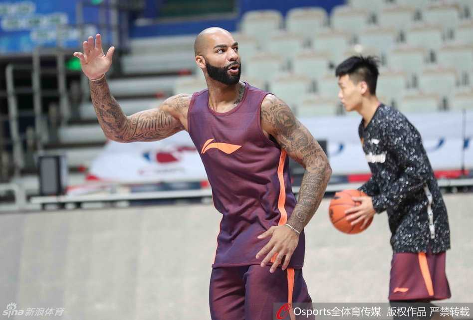 卡洛斯-布泽尔在篮下高高跃起，右手将球举过头顶，做出勾手的姿势，虽然只是训练，他脸上的表情却依然专注而凶狠。