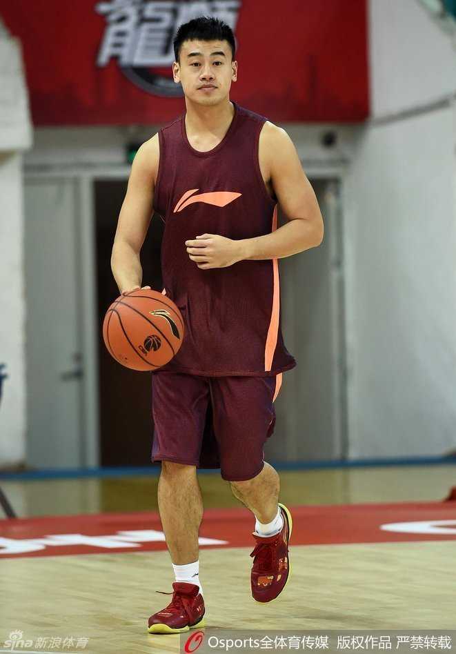 李根和李学林在场边双手紧握，笑容满面地交谈，身后的队友在激烈训练，而这两位老友仿佛回到了并肩夺冠的旧日时光，温情满满。