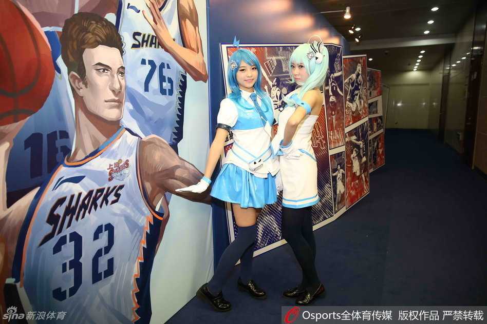 几位扮演B站2233娘的Coser在出征仪式的看台上合影留念。她们身后是‘上海哔哩哔哩篮球队’的巨大背景板，可爱的动漫造型与专业的篮球赛事标志形成了强烈的视觉反差，这张照片也成为了当天社交媒体上最热门的配图之一。