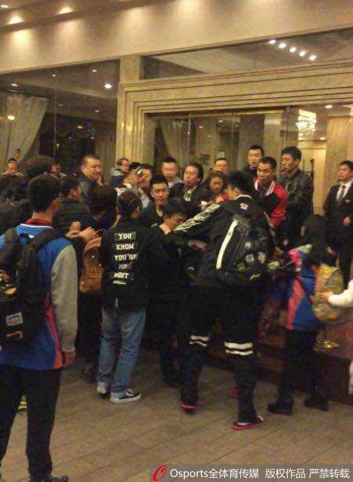 冲突平息后，酒店门口留下满地的纸屑与杂物，身穿不同颜色衣服的人群仍未完全散去，有人在打电话，有人驻足回望，现场一片狼藉与落寞。