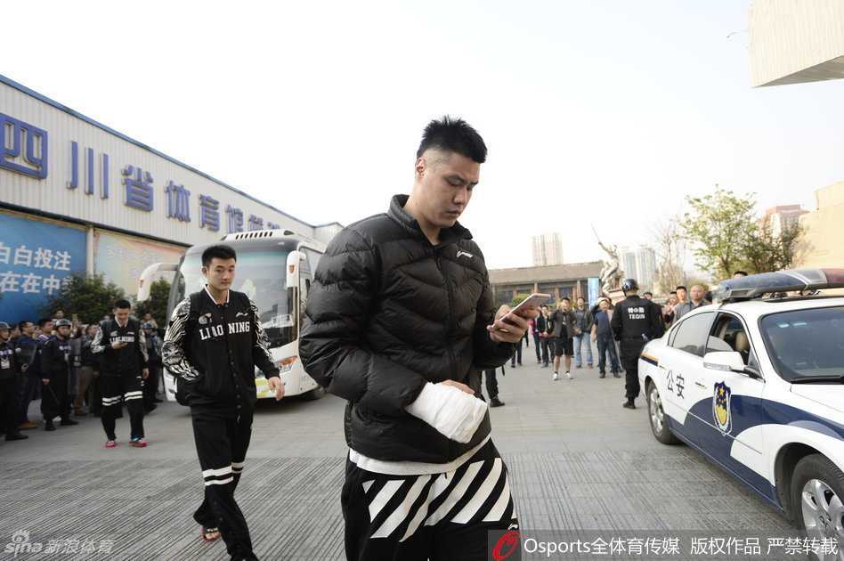 辽宁男篮中锋韩德君在安保人员的注视下走向赛场，他那庞大的身躯在空旷的通道里投下长长的影子，脸上写满了与平日温和性格不符的凝重与疲惫。