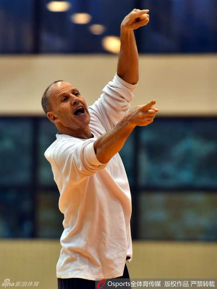 助理教练戈尔在训练场边，正对核心球员朱芳雨进行一对一的细致指导，两人神情严肃讨论战术。