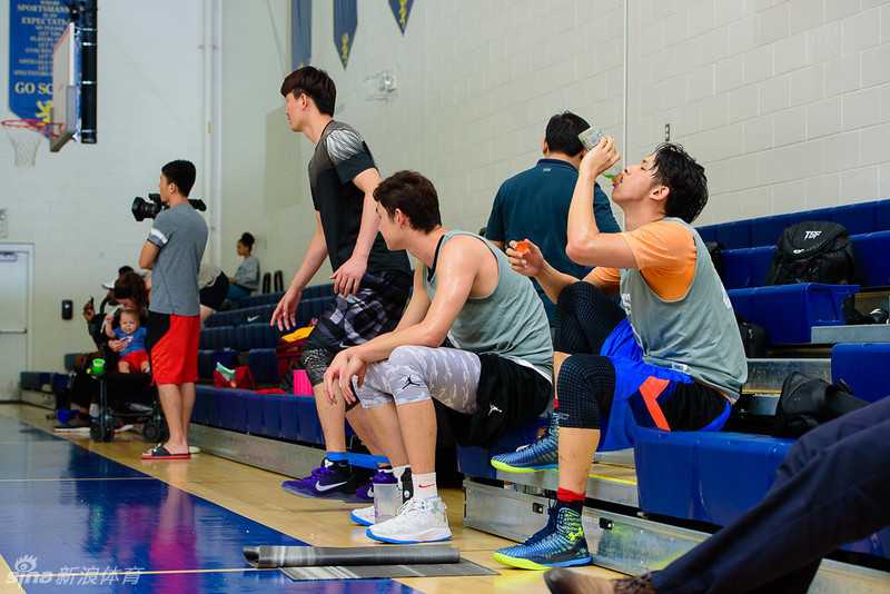 何忠勉在亚特兰大训练间隙补充水分，脸上挂满汗水，眼神坚毅地盯着远处的对抗。