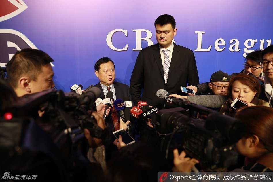 当董事长李金生（左）在交谈中侧身靠近时，姚明立刻配合地将头偏向一侧，专注地侧耳倾听，这一细微的动作展现了他对前辈的尊重以及在合作中虚心求教的态度。